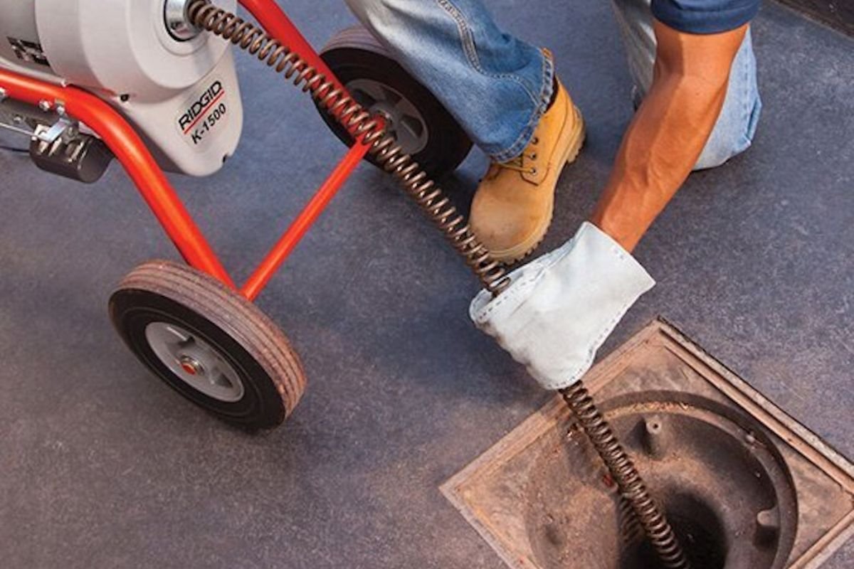 Caminhão e equipe trabalhando em desentupimento de esgoto